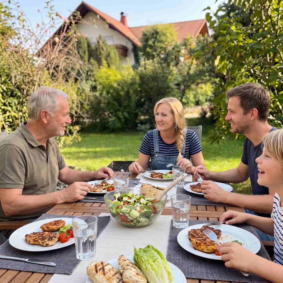 A family relaxed and eating together outdoors with no flies bothering them